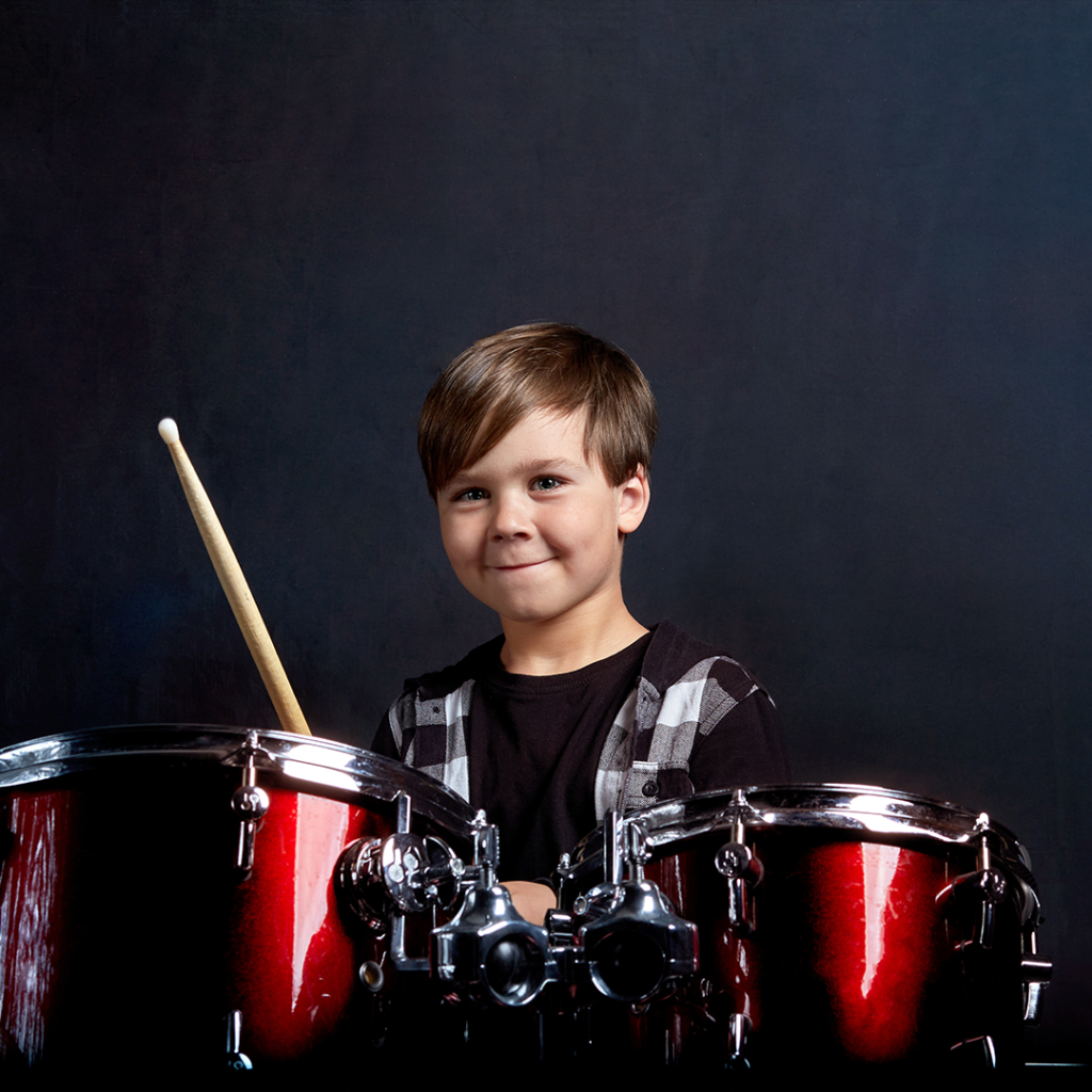 Boy playing drum set.